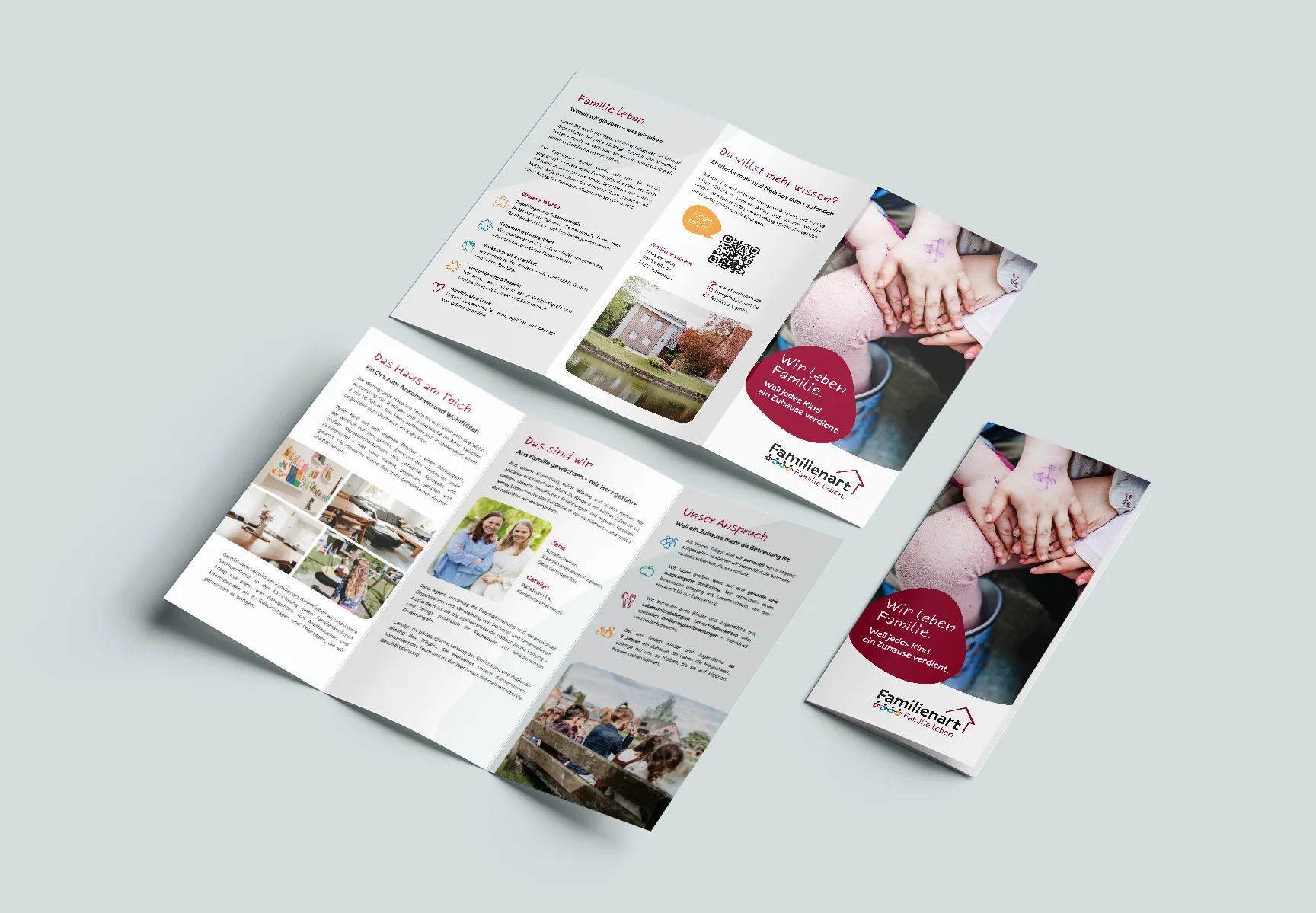 Auf einer Fläche liegt dreimal der selbe Flyer. Zwei sind aufgeklappt und zeigen die enthaltenen Informationen zur Einrichtung, zu den Geschäftsführerinnen, den Unternehmenswerten sowie Kontaktangaben. Ein Flyer ist zugeklappt und zeigt auf der Titelseite ein Foto mehrerer aufeinandergelegter Kinderhände. Die Überschrift lautet: „Wir leben Familie. Weil jedes Kind ein Zuhause verdient.“